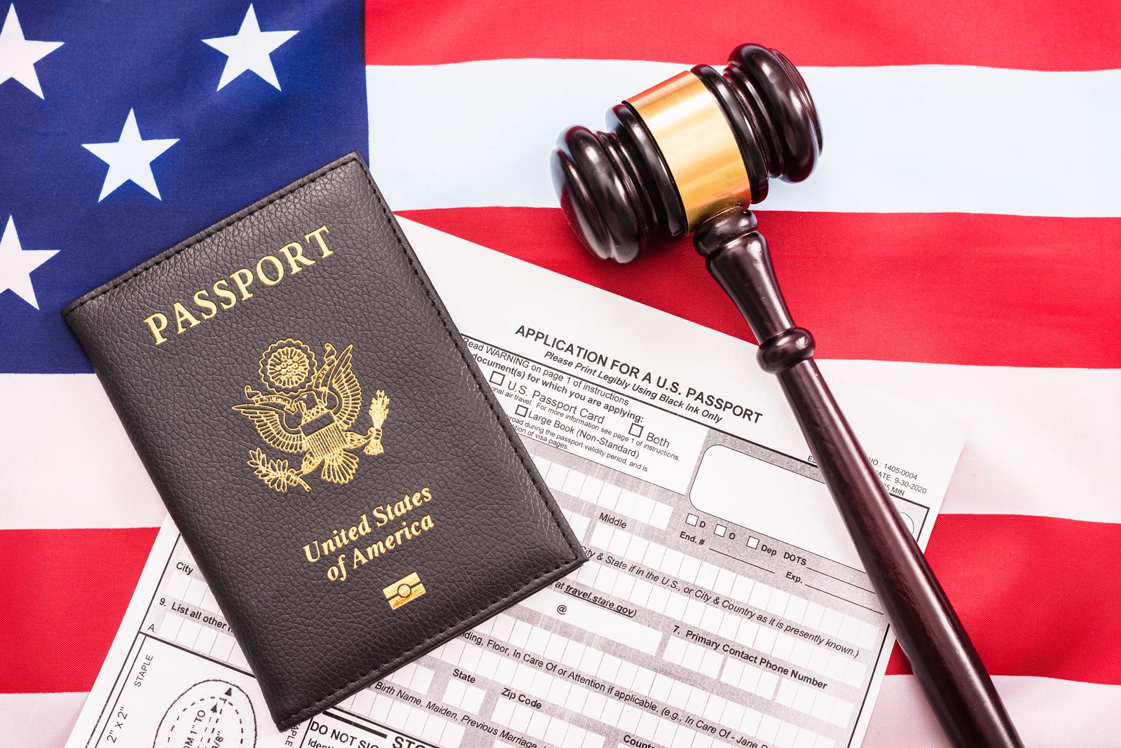 A passport application document with a gavel on the American flag