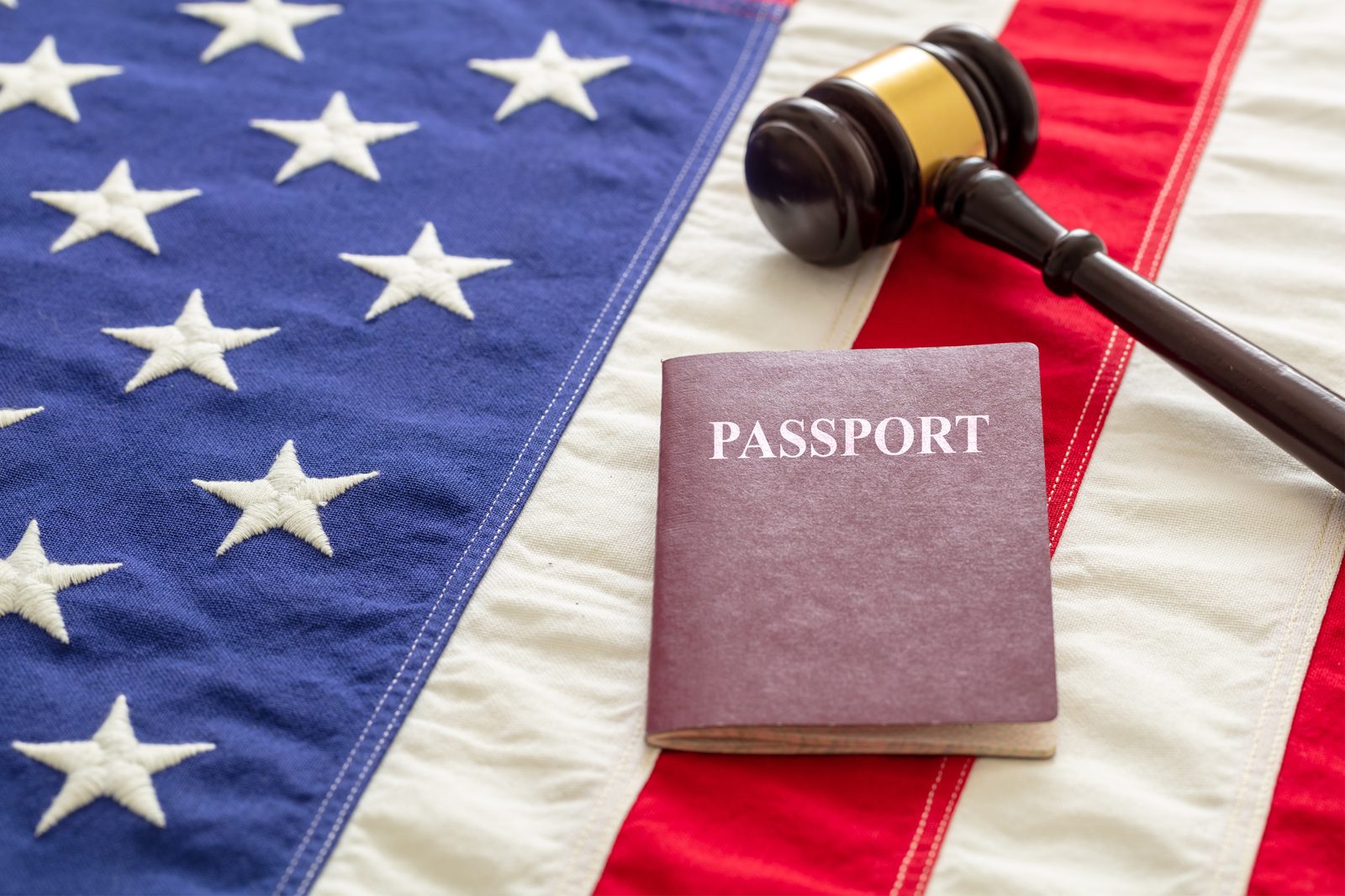 A U.S. passport and gavel resting on the American flag