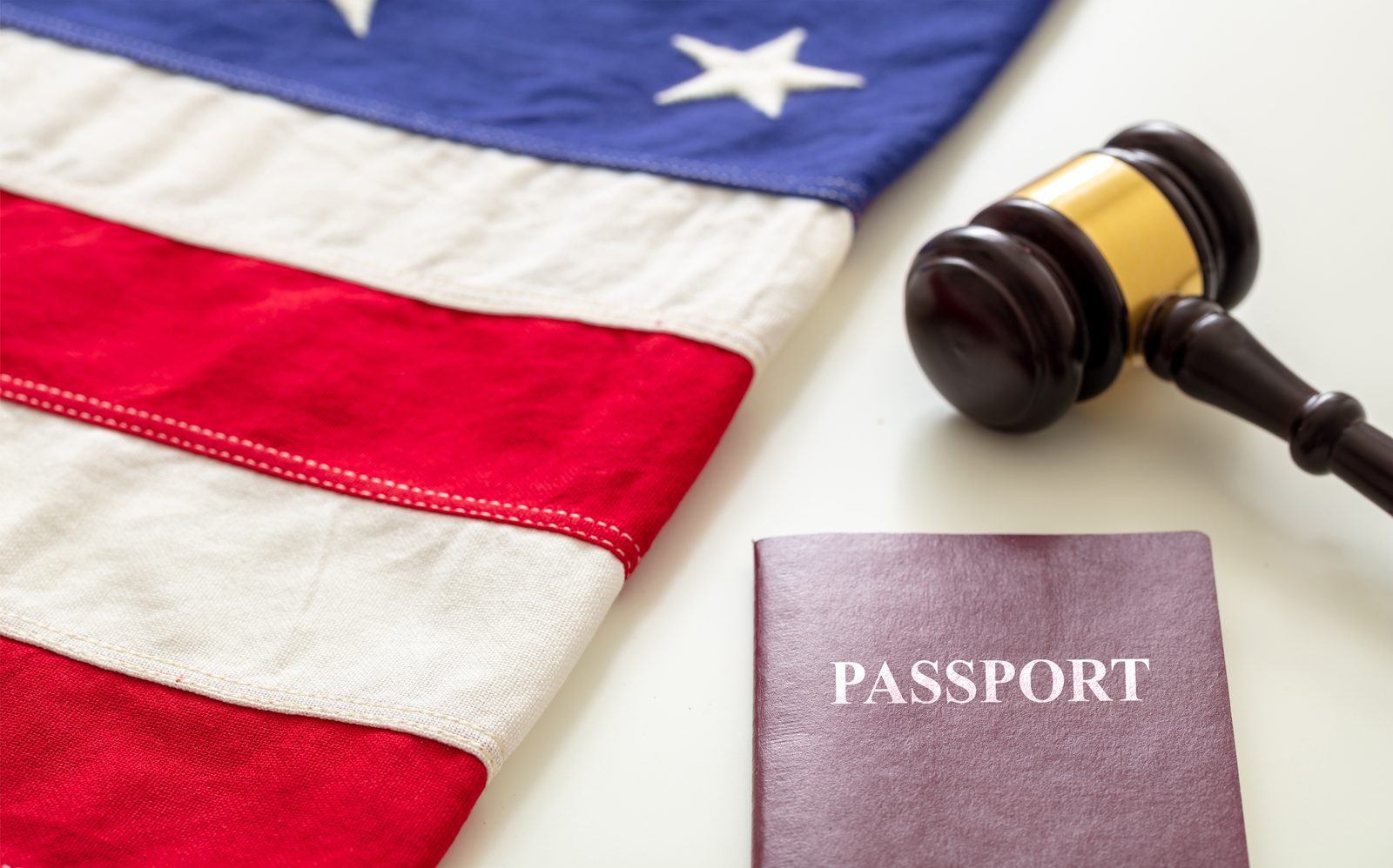 A U.S. passport and gavel arranged on a clean white surface